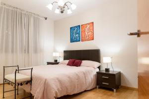奥尔迪诺AndBnB I 3 Habitaciones con Terraza y Parking的一间卧室配有床和两张桌子及椅子