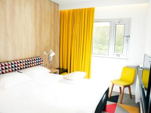 凯恩ibis Styles Caen Centre Historique的一间卧室配有床和黄色窗帘
