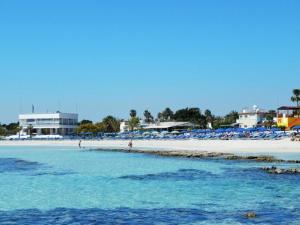 阿依纳帕Dome Beach Marina Hotel & Resort的海滩上摆放着椅子,水里人