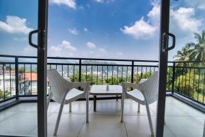 康提Amandara Hills Kandy的设有一个配有桌椅并享有美景的阳台。