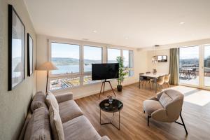 豪尔根aestate living lakeview in Horgen Zürich Zug Pfäffikon的客厅配有沙发、椅子和电视