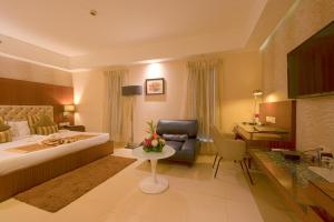 加尔各答切莱斯塔 - 加尔各答酒店的配有一张床和一张书桌的酒店客房