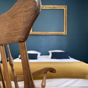桑利斯Suite Lavarande by La Boîte En Plus的一张带镜子的床上的木椅