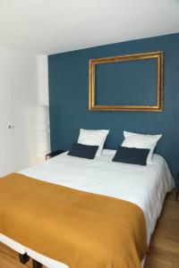 桑利斯Suite Lavarande by La Boîte En Plus的一间卧室设有一张蓝色墙壁的大床