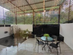 米里CASA homestay 軒名宿的客房设有桌椅和一些窗户。