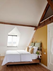 阿尔森La Dominotte Arcen的卧室配有白色的床和窗户。