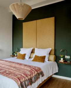 阿尔森La Dominotte Arcen的一间卧室设有一张带绿色墙壁的大床
