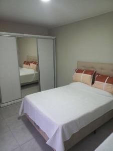 阿蒂加斯Casa amplia y bien ubicada的卧室配有一张白色大床和镜子