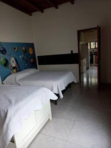 阿蒂加斯Casa amplia y bien ubicada的一间带两张床的卧室和走廊