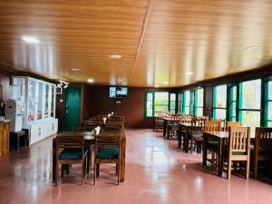 乔斯希马特Himalayan High, Auli, By Himalayan Eco Lodges的用餐室设有木桌、椅子和窗户。