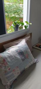 彼得罗利纳Suíte completa em condomínio fechado的枕头坐在窗前的床上