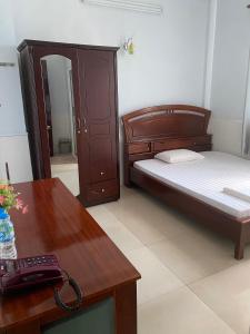 Cao LãnhKhách sạn Tường Minh的一间卧室配有一张床、一张桌子和一部电话