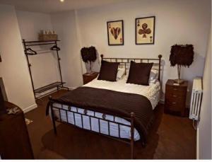 利兹The Beulah Apartments的卧室配有一张床,墙上挂有两张照片