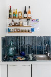 阿尔勒La Madeleine Arles的厨房配有水槽和带瓶子的台面