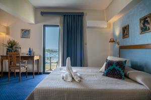 雅典四季酒店的酒店客房设有一张带书桌的床和一个阳台。