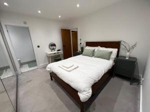 Streatham ValeStreatham House - Modern Detached 2 Bedroom House in Streatham Common的一间卧室配有一张带白色床单的大床