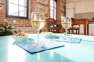AuteriveÉvasions-Escapade, centre-ville, gare的桌子上坐着两杯白葡萄酒