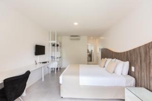 卡姆布库Duro Beach Garden Hotel的卧室配有一张白色大床和一张书桌