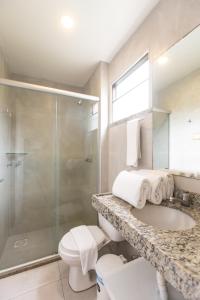 卡姆布库Duro Beach Garden Hotel的带淋浴、盥洗盆和卫生间的浴室