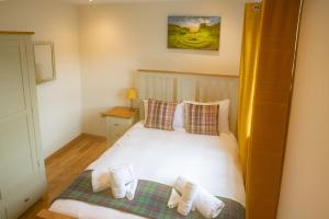 卡博斯特Luxury 3 Bedroom Cottage With Stunning Views Near Fairy Pools!的卧室配有白色床和毛巾
