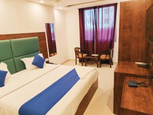 新德里Hotel Tela Suite Plaza Near IGI Airport的卧室配有床、椅子和窗户。