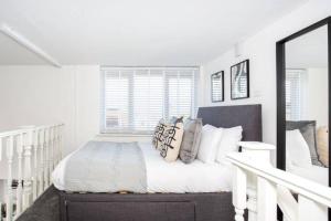 滨海绍森德Loft Style Apartment w/ Parking, in Leigh-on-Sea的白色卧室配有带枕头的床