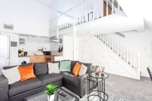 滨海绍森德Loft Style Apartment w/ Parking, in Leigh-on-Sea的带沙发和楼梯的客厅
