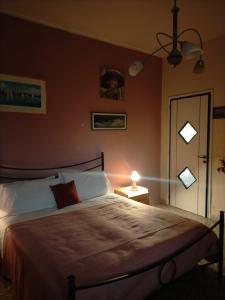 锡拉库扎Sleep In Sicily的一间卧室配有一张大床、一盏灯和一扇门