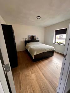 WaalreLuxe recreatiewoning midden in bosrijke omgeving的一间卧室配有一张床,铺有木地板