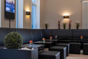 柏林斯比特尔马克西佳酒店的一间设有黑色椅子和桌子的等候室