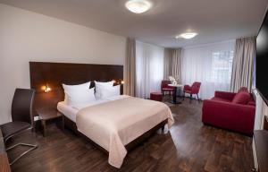 柏林斯比特尔马克西佳酒店的酒店客房,配有一张床和一张红色椅子