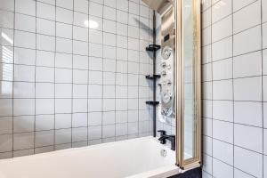 伯肯黑德Lavish 2BR Bungalow Retreat in Birkenhead的白色瓷砖浴室设有浴缸和镜子