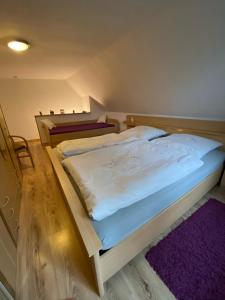 弗雷门Ferienwohnung bi Klatt tu Hus的卧室配有一张白色大床和紫色地毯