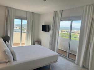 普拉加德阿罗阿罗玛酒店的卧室设有白色的床和大窗户