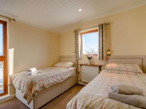 索厄比布里奇2 Bed in Sowerby Bridge 90887的一间卧室设有两张床和两个窗户。