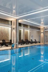 米泽德沃兹Juvena Hotel Wellness & SPA的一座配有桌椅的酒店游泳池