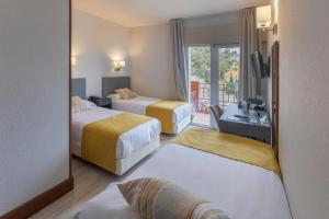 马拉加Soho Boutique Los Naranjos的酒店客房设有两张床和一个阳台。