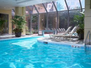 唐纳斯格罗夫Homewood Suites By Hilton Downers Grove Chicago, Il的一个带两把椅子的酒店游泳池和一个游泳池