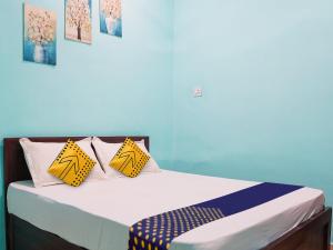 比拉斯布尔OYO Hotel Hanu Inn的一间卧室配有黄色和蓝色枕头的床