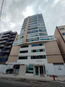 瓜拉派瑞Ivana Imoveis - Grupo de Aptos Temporada - Praia do Morro的街道上高大的建筑
