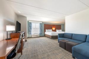 费南迪纳比奇Surf and Sand Fernandina Beach at Amelia Island, Ascend Hotel Collection - Formerly Comfort Suites的酒店客房,配有床和沙发