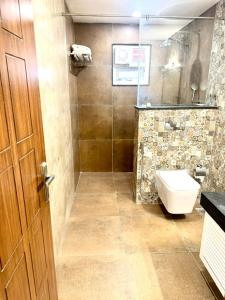 NandiSummer House Nandi Foothills的一间带卫生间和玻璃淋浴间的浴室