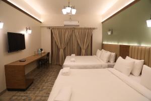 NandiSummer House Nandi Foothills的酒店客房配有两张床和一张书桌