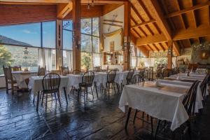 圣卡洛斯-德巴里洛切Hosteria El Condado by Nordic的用餐室配有桌椅和大窗户