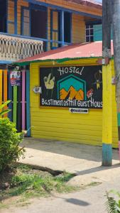 博卡斯德尔托罗Bastimentos Hill Guest House的黄色的建筑,旁边标有标志