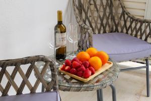 雅典Magnificent Riviera Residence的一张桌子,上面放着一盘水果和一瓶葡萄酒