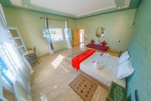 马拉喀什Villa Coup De Cœur的一间卧室配有一张床铺,床上铺有红色毯子