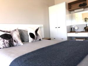 开普敦Small Bay Beach Suites的一间卧室配有一张大床和两个枕头