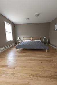 泽西市2-Bed Stylish Space mins to NYC的一间卧室配有一张床,铺有木地板