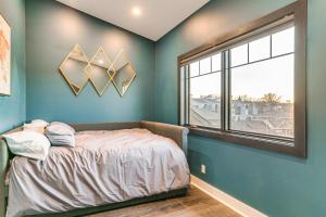 奥马哈Stylish Omaha Home with Balcony - 2 Mi to Downtown!的蓝色的卧室设有床和窗户